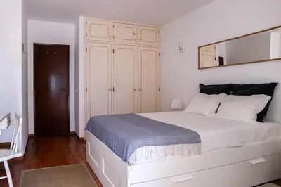a bedroom with a large white bed with a mirror at Beach House at Praia da Luz in Luz