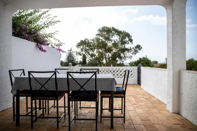 a dining room table and chairs on a patio at Beach House at Praia da Luz in Luz