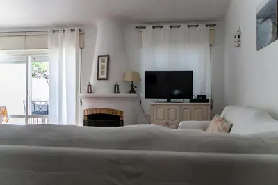 a bedroom with a bed and a tv and a fireplace at Beach House at Praia da Luz in Luz