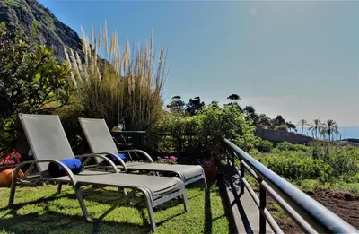 a couple of chairs sitting on top of the grass at Sunset Sea Breeze in Madalena do Mar