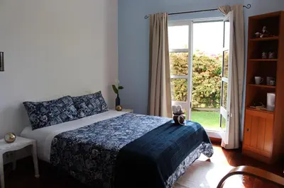 a bedroom with a bed and a large window at Sunset Sea Breeze in Madalena do Mar