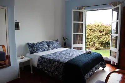 a bedroom with a bed and a large window at Sunset Sea Breeze in Madalena do Mar