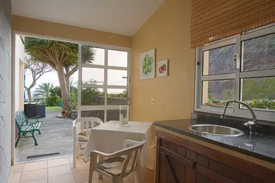 a kitchen with a sink and a table with chairs at Sunset Sea Breeze in Madalena do Mar