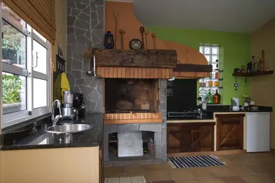 a kitchen with a fireplace and a sink at Sunset Sea Breeze in Madalena do Mar