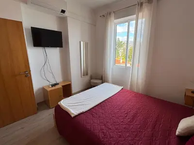a bedroom with a red bed and a window at Casa das Cruzes in Funchal
