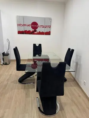 a living room with a white wall and a table and chairs at Casa das Cruzes in Funchal