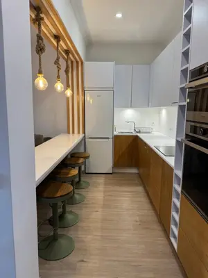 a kitchen with white appliances and wooden cabinets at Casa das Cruzes in Funchal