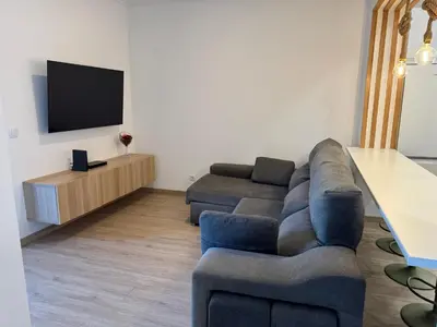 a living room with a couch and a tv at Casa das Cruzes in Funchal