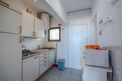 a small kitchen with white cabinets and a sink at Vista Oceano II in Caniço