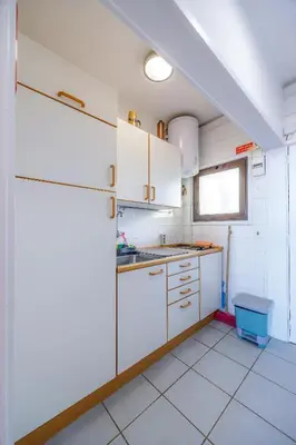 a kitchen with white cabinets and a sink at Vista Oceano II in Caniço