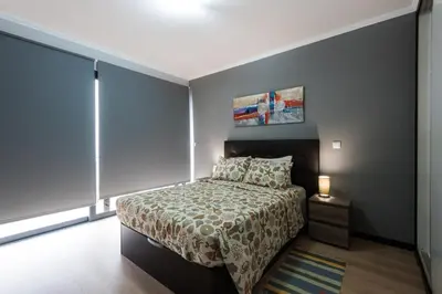 a small bedroom with a bed and a lamp at Casa do Louro in Arco da Calheta