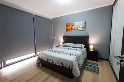 a bedroom with a bed and a painting on the wall at Casa do Louro in Arco da Calheta