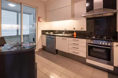 a kitchen with stainless steel appliances and a table at Oceanside Terrace Apartment by Holiday Rental Madeira in Funchal