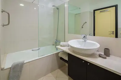a bathroom with a sink and a glass shower at Oceanside Terrace Apartment by Holiday Rental Madeira in Funchal