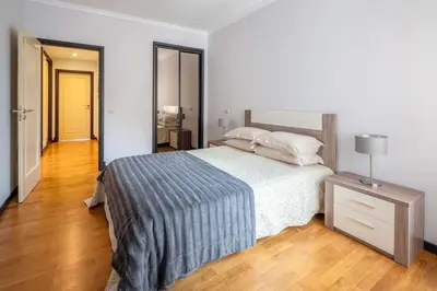 a bedroom with a bed and a night stand with a lamp at Oceanside Terrace Apartment by Holiday Rental Madeira in Funchal