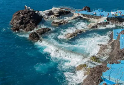 an island in the ocean with a water slide at Oceanside Terrace Apartment by Holiday Rental Madeira in Funchal