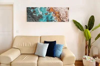 a couch in a living room with a painting on the wall at Luzias Apartment in Funchal
