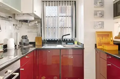 a kitchen with red cabinets and a sink at Luzias Apartment in Funchal