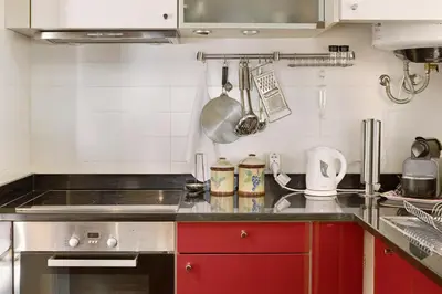 a kitchen with a stove and red cabinets at Luzias Apartment in Funchal