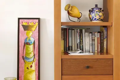 a book shelf filled with books and a vase at Luzias Apartment in Funchal