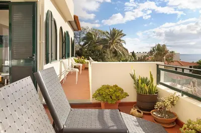 a balcony with two chairs and a table at Luzias Apartment in Funchal