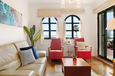 a living room with red chairs and a couch at Luzias Apartment in Funchal