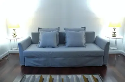 a blue couch in a living room with two tables at Pimenta Funchal Downtown in Funchal