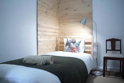 a bedroom with a bed with a wooden wall at Pimenta Funchal Downtown in Funchal