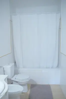 a white bathroom with two toilets and a mirror at Pimenta Funchal Downtown in Funchal
