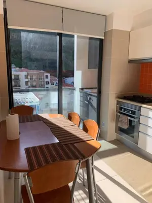 a kitchen with a wooden table and a large window at Giesta Flower by Madeira Holiday Rentals in Ribeira Brava