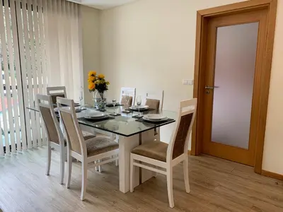 a dining room with a table with chairs and a vase of flowers at Giesta Flower by Madeira Holiday Rentals in Ribeira Brava
