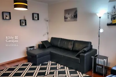 a black leather couch in a living room at Klify Garajau in Caniço