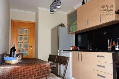 a kitchen with a table with a bottle of wine at Klify Garajau in Caniço