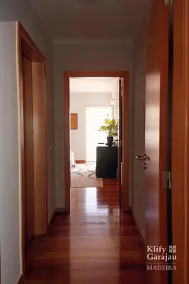 an empty hallway with a door leading to a room at Klify Garajau in Caniço