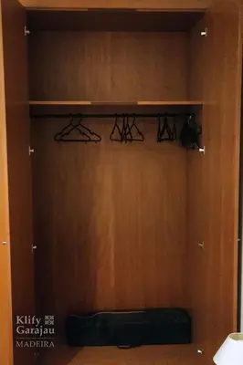 a closet with a wooden wall with a bench in it at Klify Garajau in Caniço