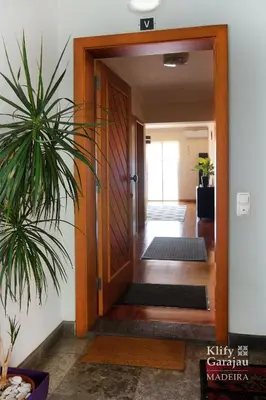 an open door to a hallway with a plant at Klify Garajau in Caniço