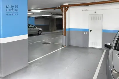 a parking garage with a car parked in it at Klify Garajau in Caniço