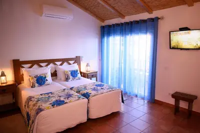a bedroom with a large bed with two night stands at Falésias da Arrifana in Praia da Arrifana