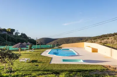 a backyard with a swimming pool in the grass at Falésias da Arrifana in Praia da Arrifana