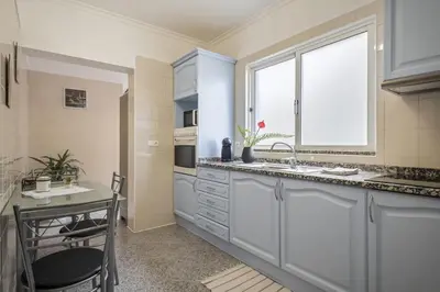 a kitchen with white cabinets and a window at Sea View Apartment in Santa Cruz