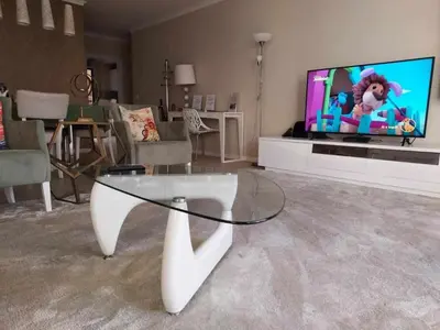 a living room with a glass table and a tv at GuestReady - Nora Premium in Funchal