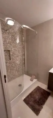a bathroom with a shower with a rug in it at GuestReady - Nora Premium in Funchal