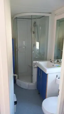 a bathroom with a shower and a toilet and a sink at Parque de Campismo Orbitur Sagres in Sagres