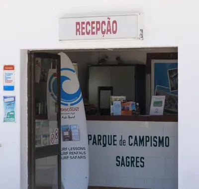 a store with a surfboard on the wall and a sign at Parque de Campismo Orbitur Sagres in Sagres