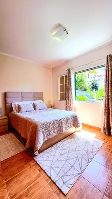 a bedroom with a bed and a large window at Casa Ventura in Arco da Calheta