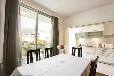 a kitchen with a white table and a large window at Dolce Vita - City Center & Shopping Center in Funchal