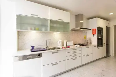 a kitchen with white cabinets and a sink at Dolce Vita - City Center & Shopping Center in Funchal