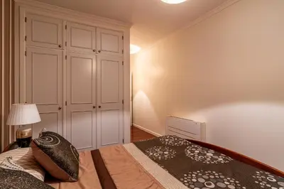 a bedroom with a bed with a lamp and a cabinet at Casa Branca with garden by Holiday Rental Madeira in Funchal