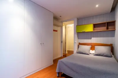a bedroom with a bed with white walls and wooden floors at Casa Branca with garden by Holiday Rental Madeira in Funchal