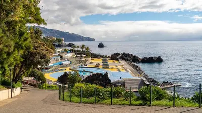 a view of a swimming pool next to the ocean at Casa Branca with garden by Holiday Rental Madeira in Funchal
